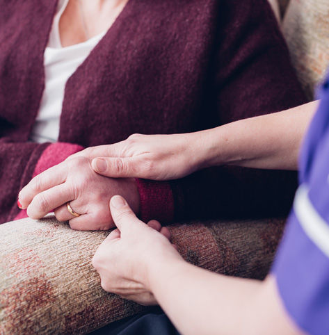 Close up image of a nurse holding a patient's hands