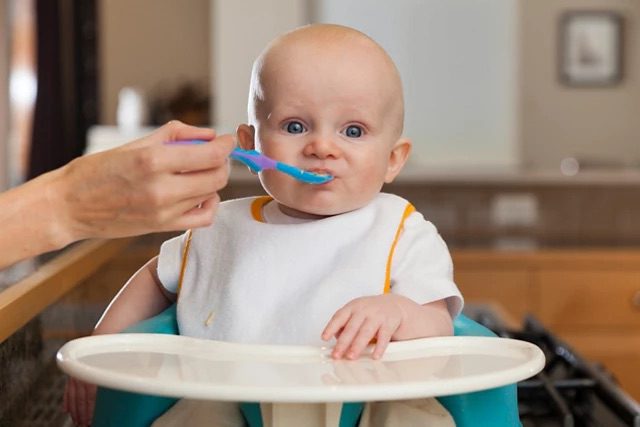 baby-holding-bowl-of-food