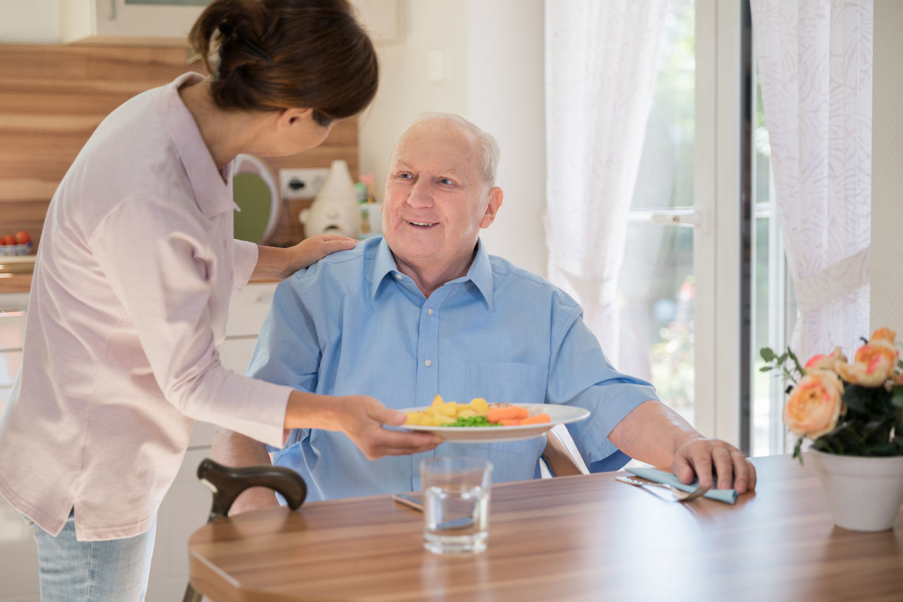 Home caregiver â   woman helping senior man