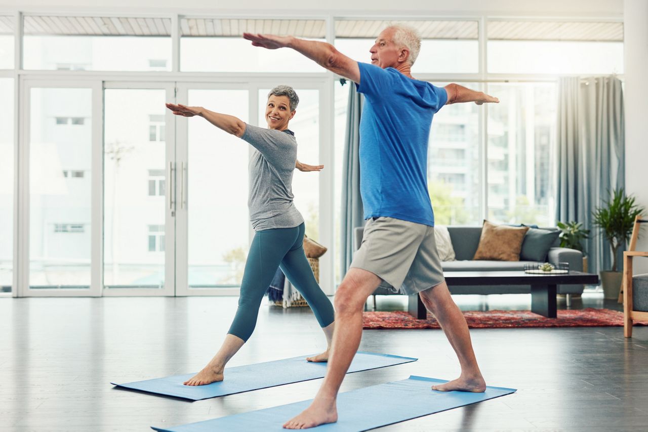 Full length shot of an active senior couple exercising together inside their home