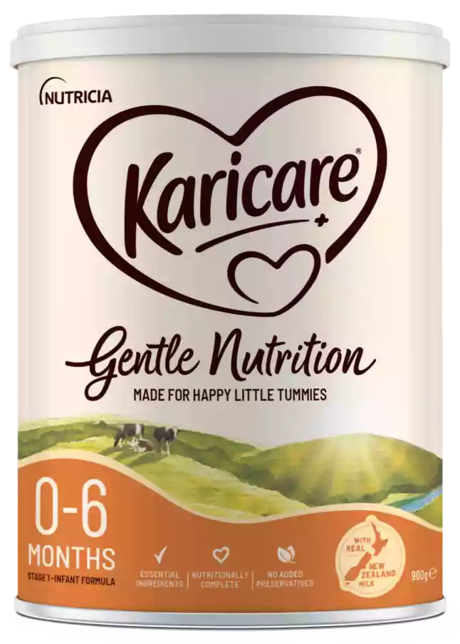 A Karicare Gentle Nutrition baby formula tin is shown against a transparent background. The front label highlights that it is suitable for 0-6 months and is a stage 1 follow-on formula. The design features a heart-shaped Karicare mark, soft cream and purple colors, and an illustrated pastoral landscape with cows. Additional text mentions essential ingredients, supports nutritional needs, no added preservatives, and that it is made with real New Zealand milk, with a net weight of 900 g.