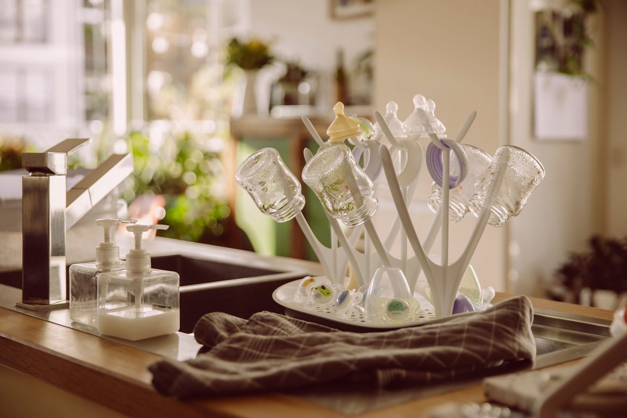 Collection of sterilized baby milk bottles in kitchen at home