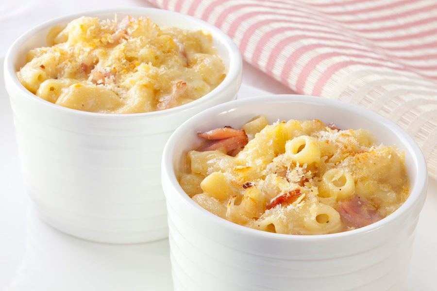 Individual servings of macaroni cheese with bacon and onion, topped with breadcrumbs.