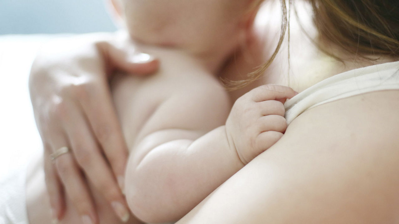Mama sosteniendo a su bebe recien nacido