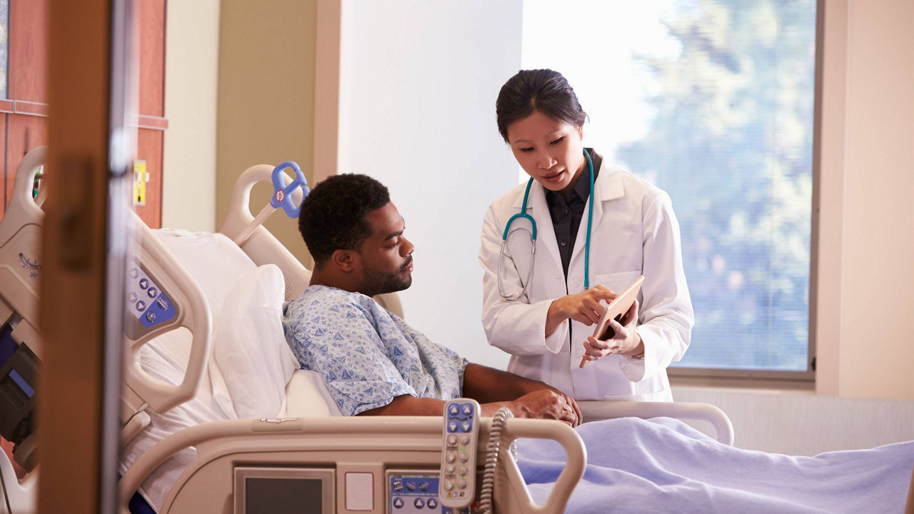 man-in-hospital-bed-with-nurse