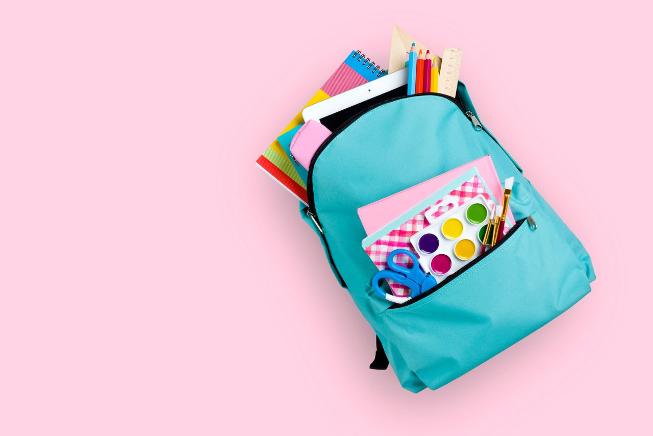 Full school backpack isolated on pink background