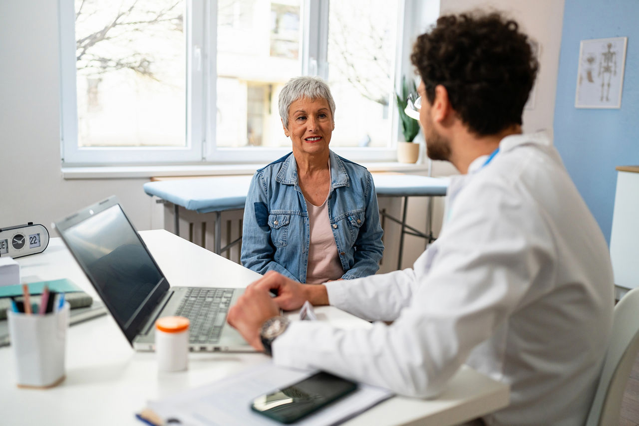 Senior Caucasian female patient, having an annual medical check-up with an young Caucasian male doctor, at the ordination