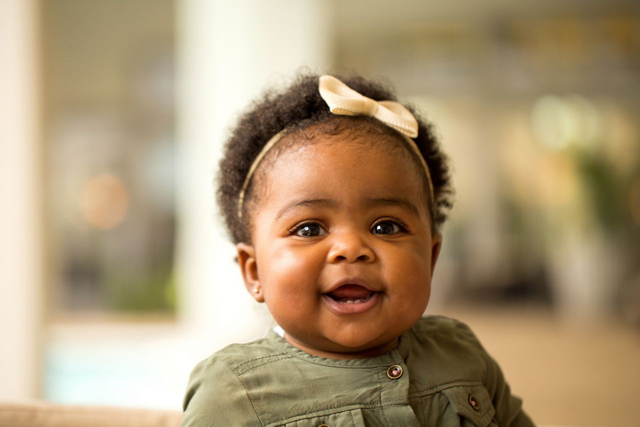 African American baby girl laughing and smiling.
