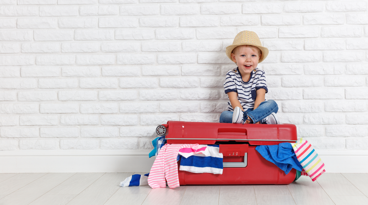 concept travel. a happy funny boy child with suitcase