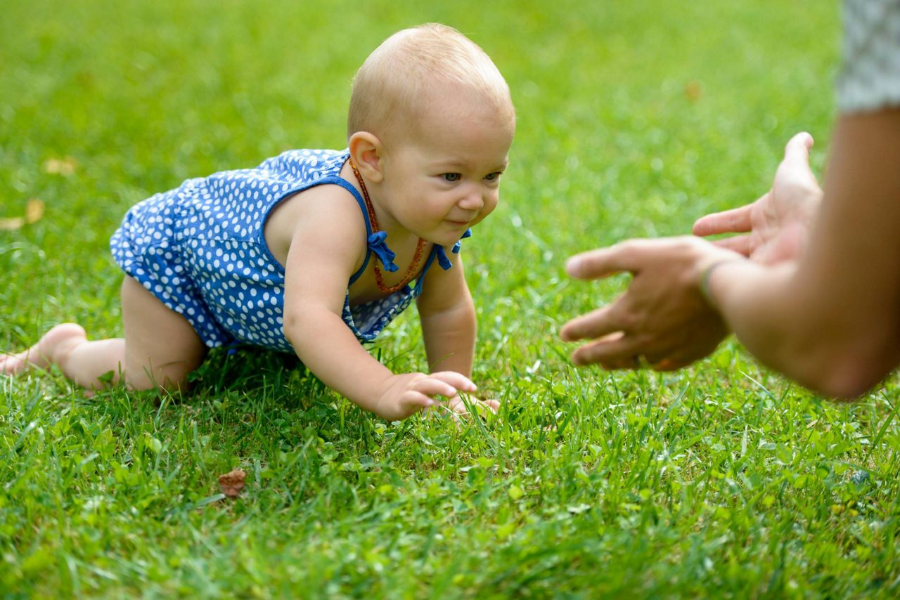 Baby krabbelt in die Arme von Mama