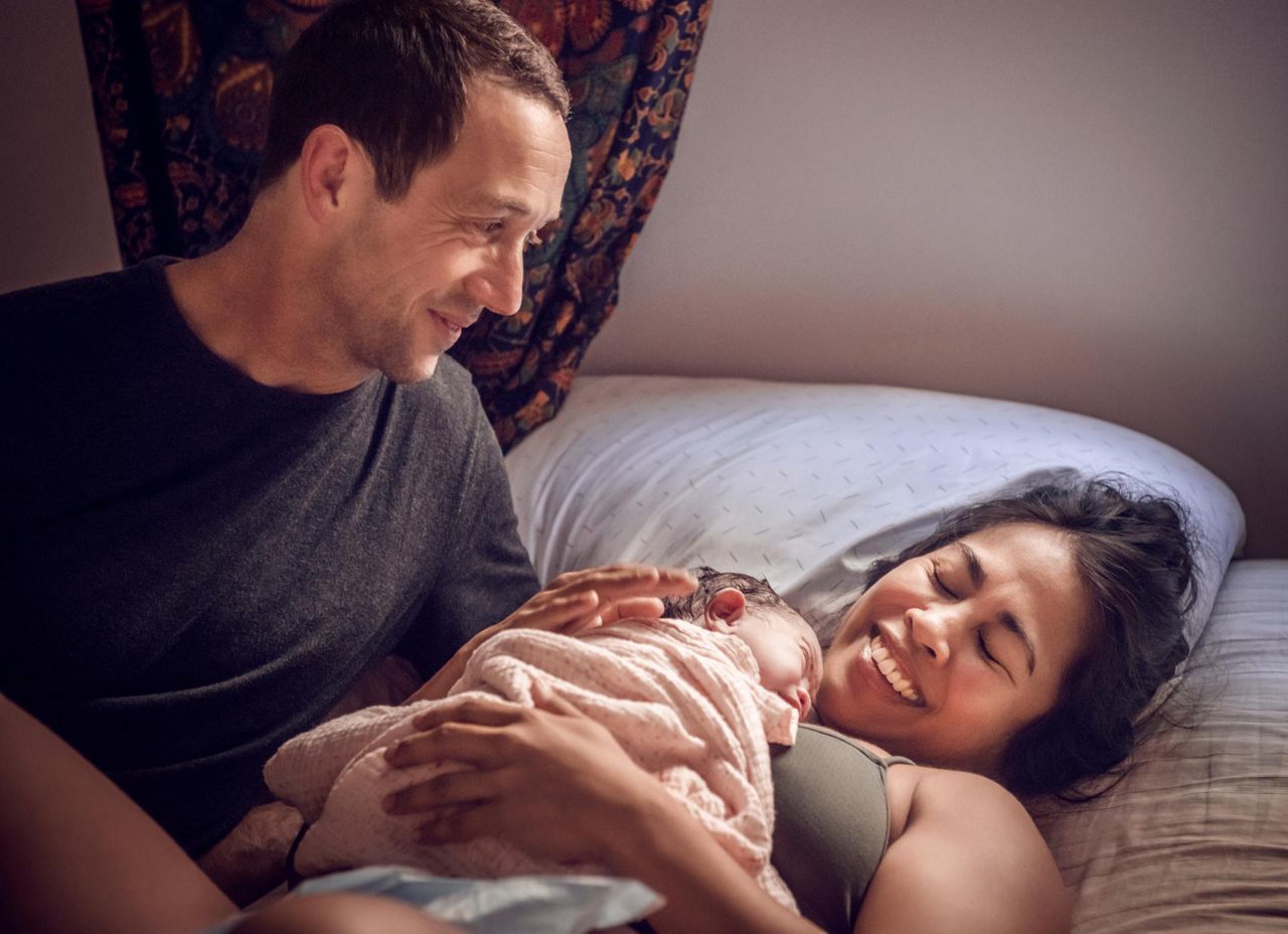 Mutter hält Babybauch auf der Yogamatte