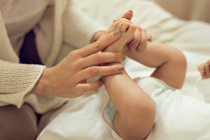 Mutter massiert Babyfüße Nahaufnahme