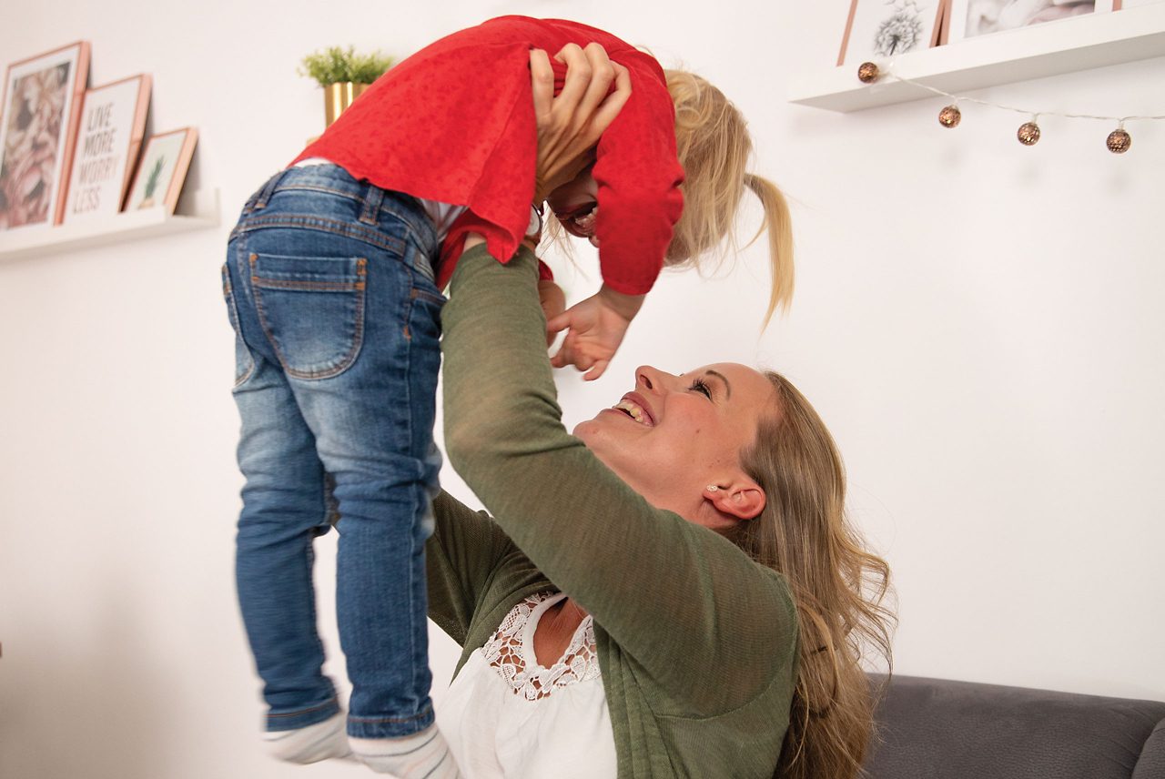Mutter hebt Kleinkind in die Luft