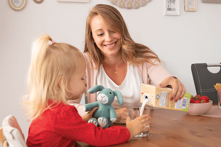 Mutter schenkt Kind mit Pauly Milupa Kindermilch ein