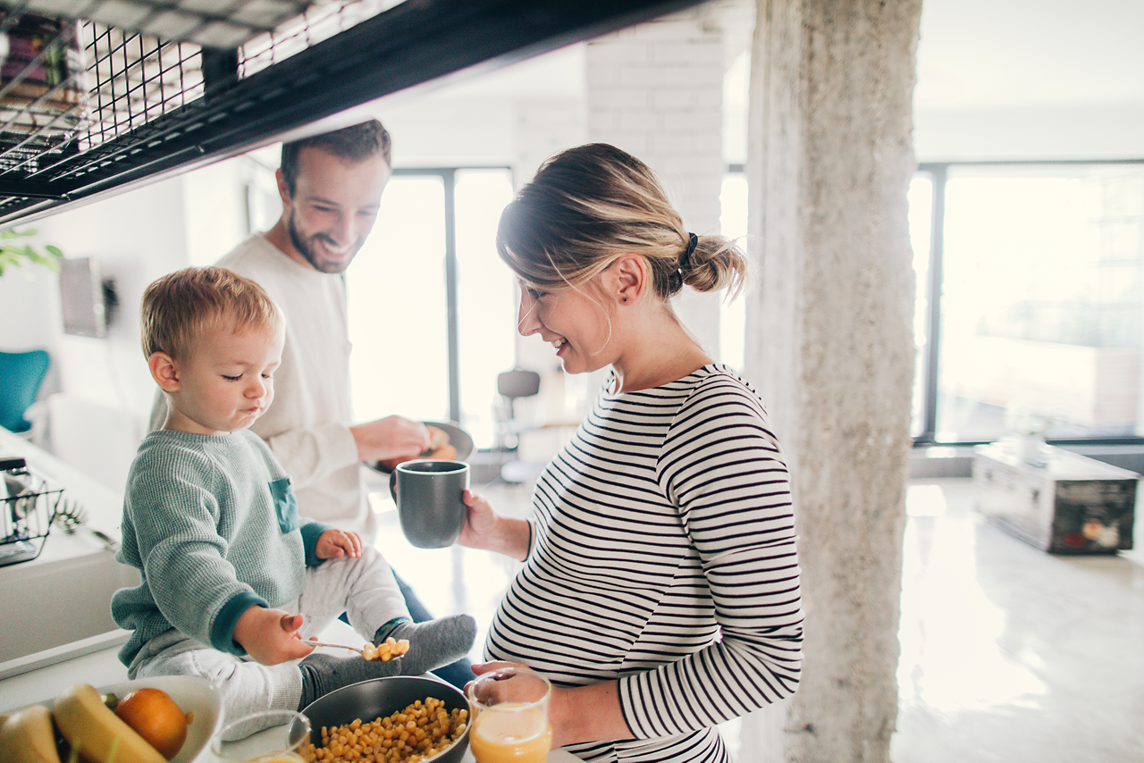 Schwangere Mutter mit Partner und Kleinkind in der Küche