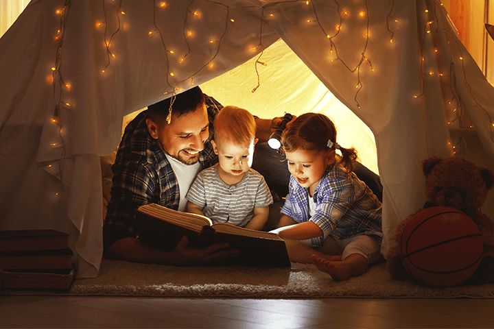 Vater mit Kleinkindern in einer Höhle zu Hause