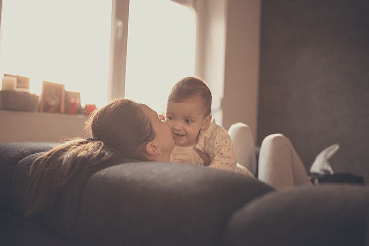 Mutter küsst Baby auf der Couch