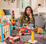 Frau sitzt im Kinderzimmer
