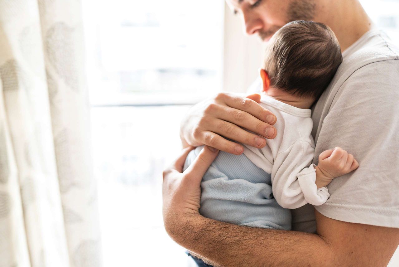 Vater hält Baby im Arm  
