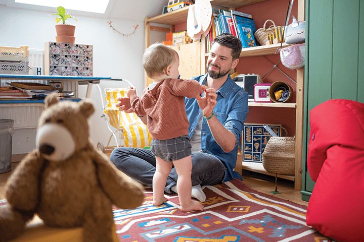 Vater spielt mit Kleinkind im Kinderzimmer