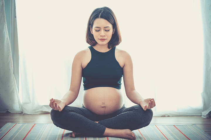 Schwangere meditiert auf einer Yogamatte