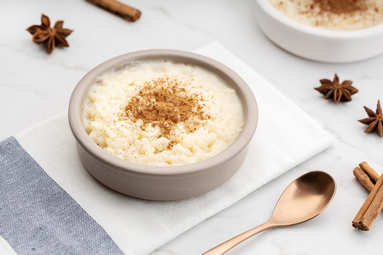 Creamy rice pudding with cinnamon in bowl on white marble table. Typical Spanish dessert