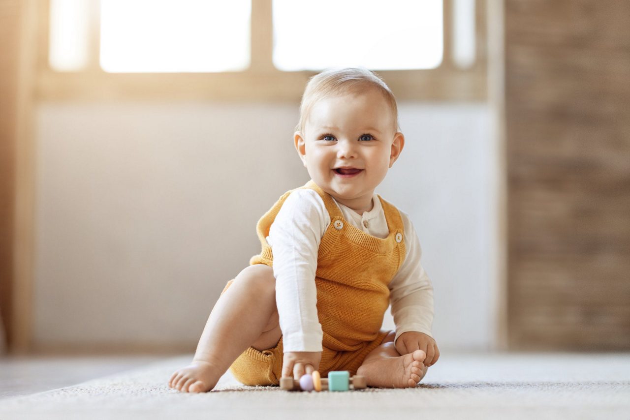 Baby sitzend und lachen auf dem Boden