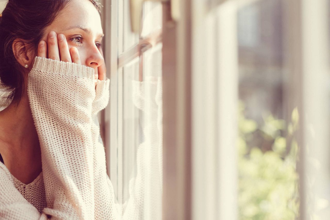 Frau schaut aus dem Fenster