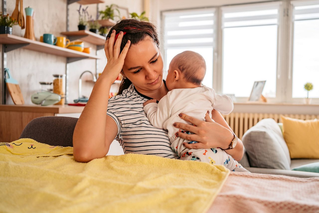 Gestresste Mutter hält ihr Baby