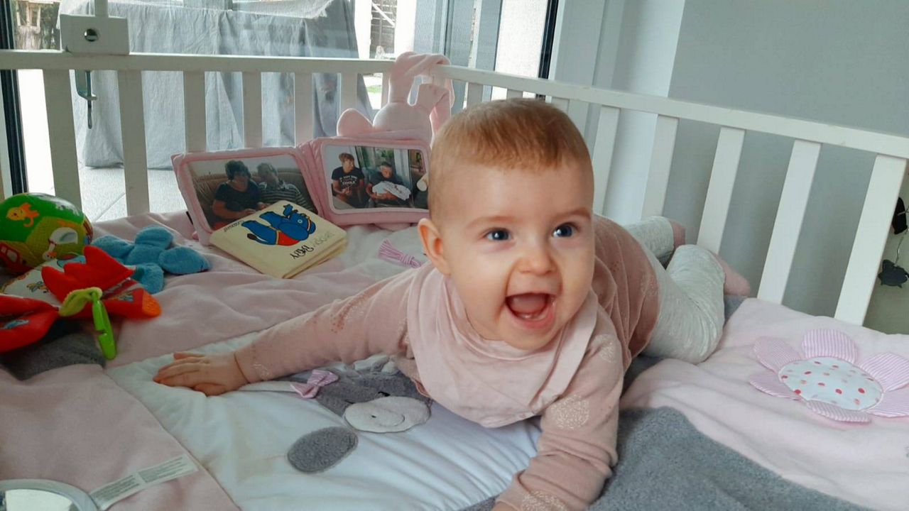 Baby lachend und krabbelnd im Bettchen
