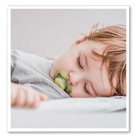 Kleinkind verdeckt sich mit dem Arm die Augen