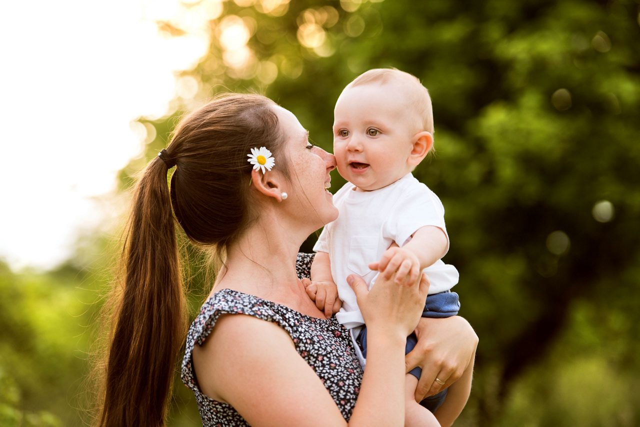 Mutter hält glückliches Baby in den Armen