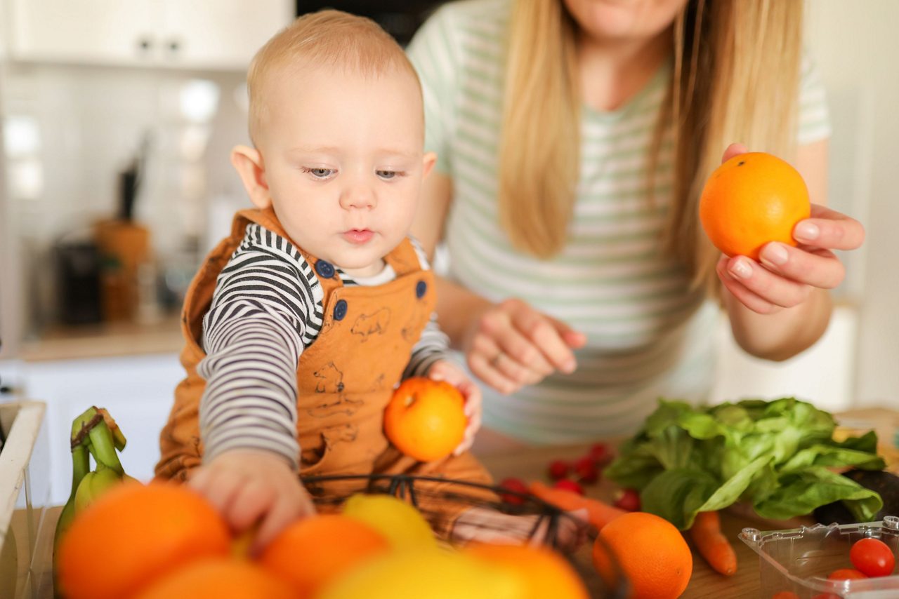 Baby hält eine Orange