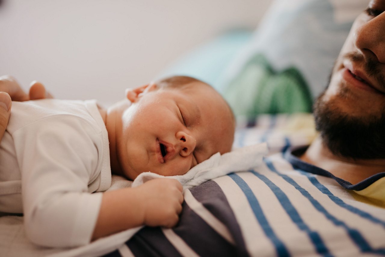 Baby schlafend auf der Brust vom Vater