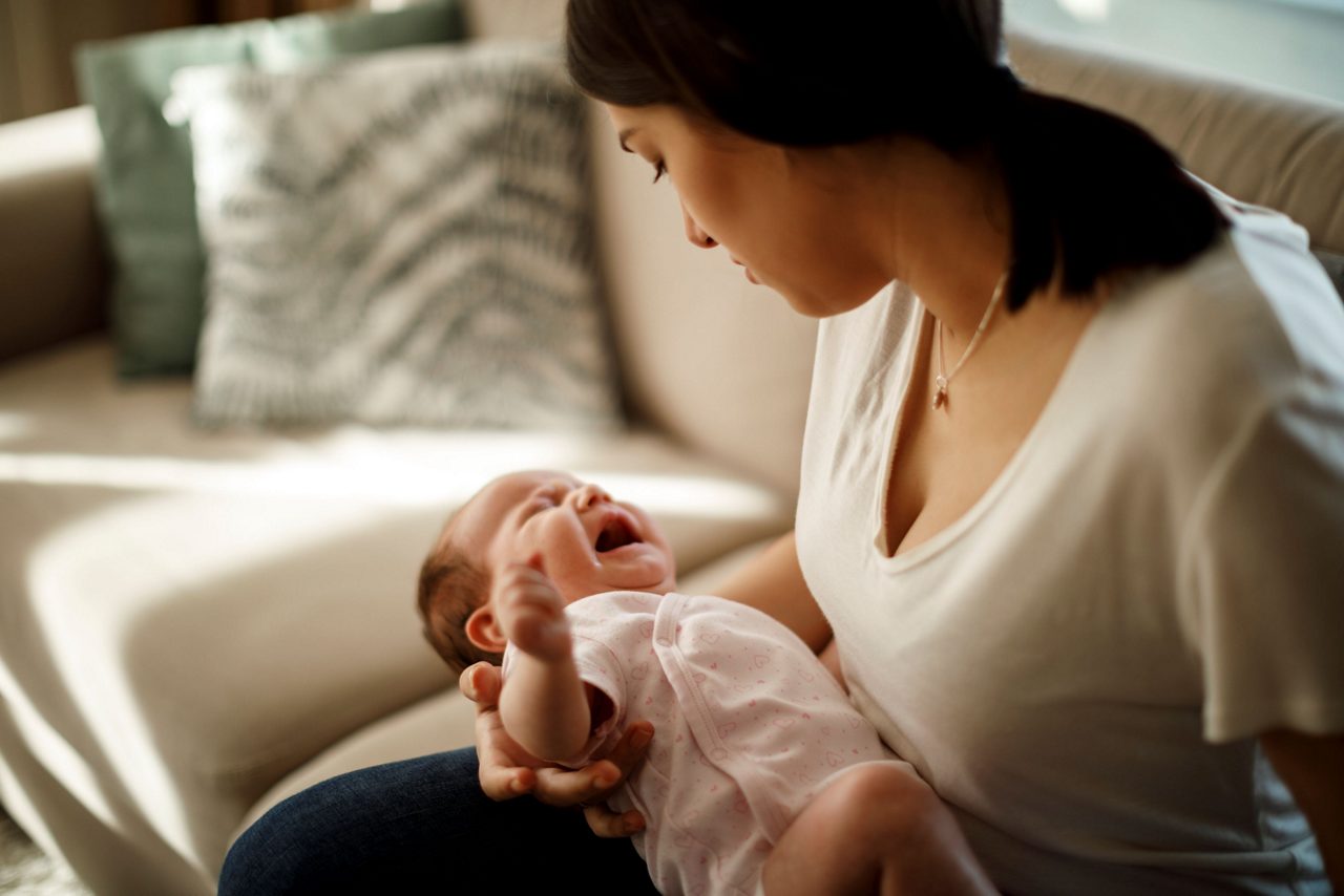 Mutter hält weinendes Baby in der Hand