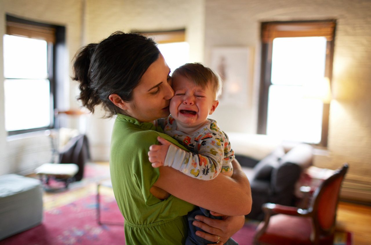 Baby schreit auf Arm der Mutter