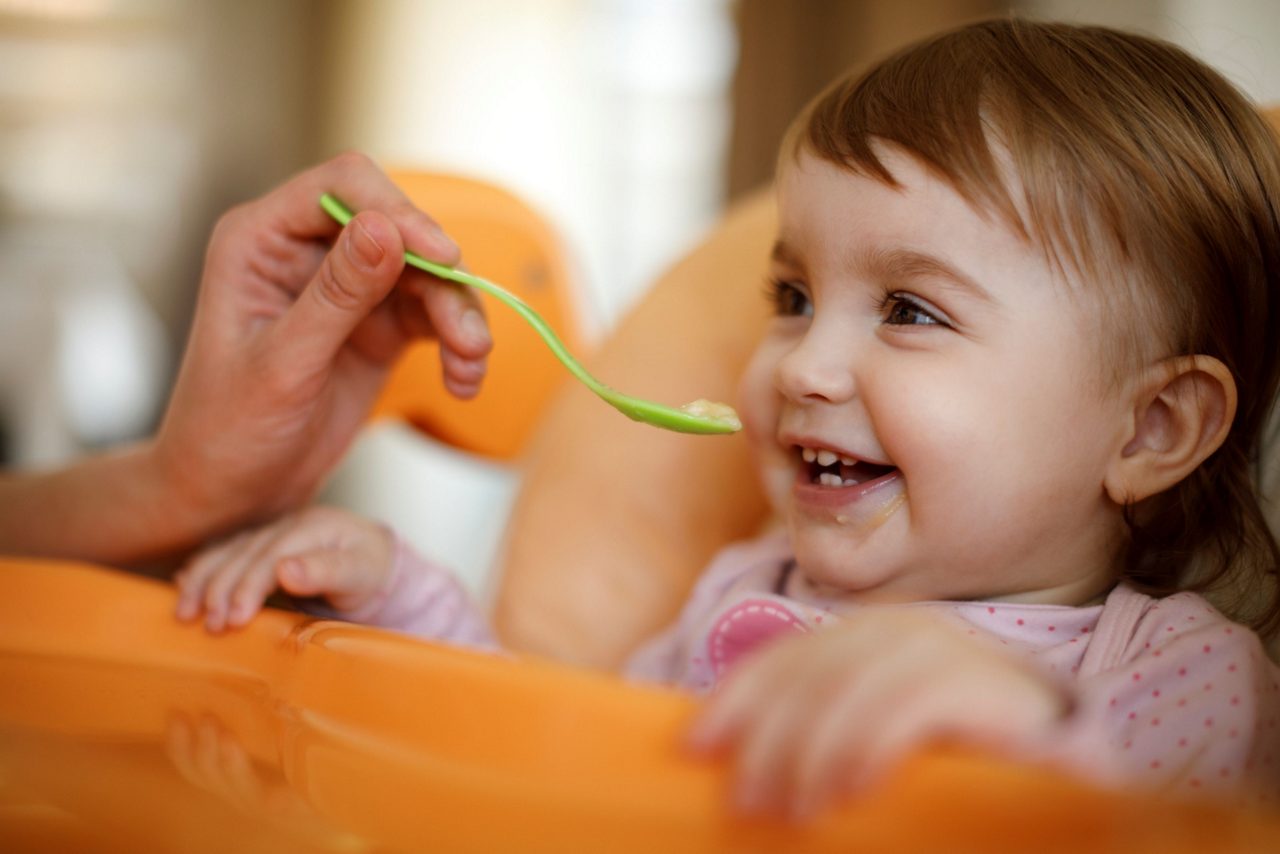 Baby mit Löffel im Mund