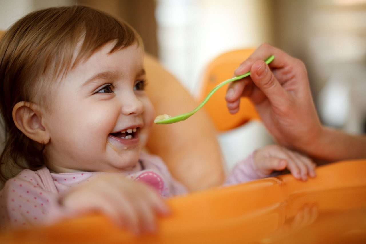 Baby wird mit Brei gefüttert