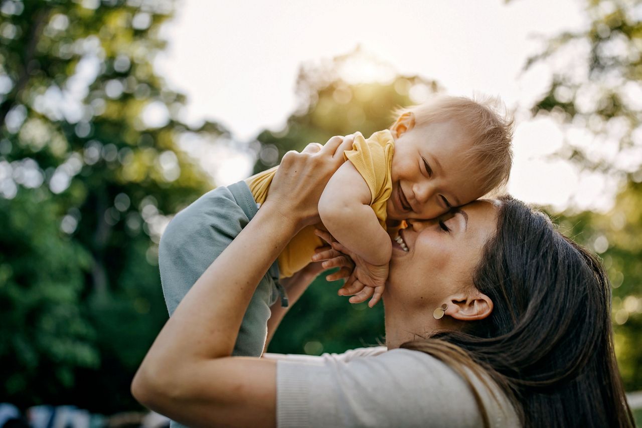 Mutter hebt glückliches Baby hoch