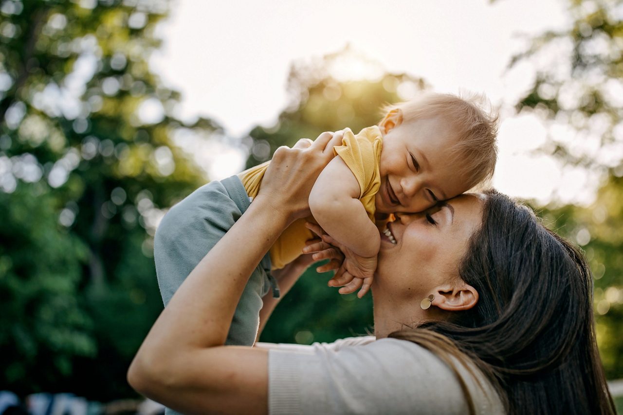 Mutter hält lachendes Baby im Arm