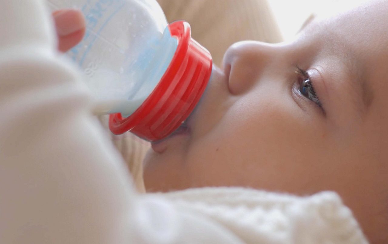 Baby trinkt aus dem Fläschchen Nahaufnahme