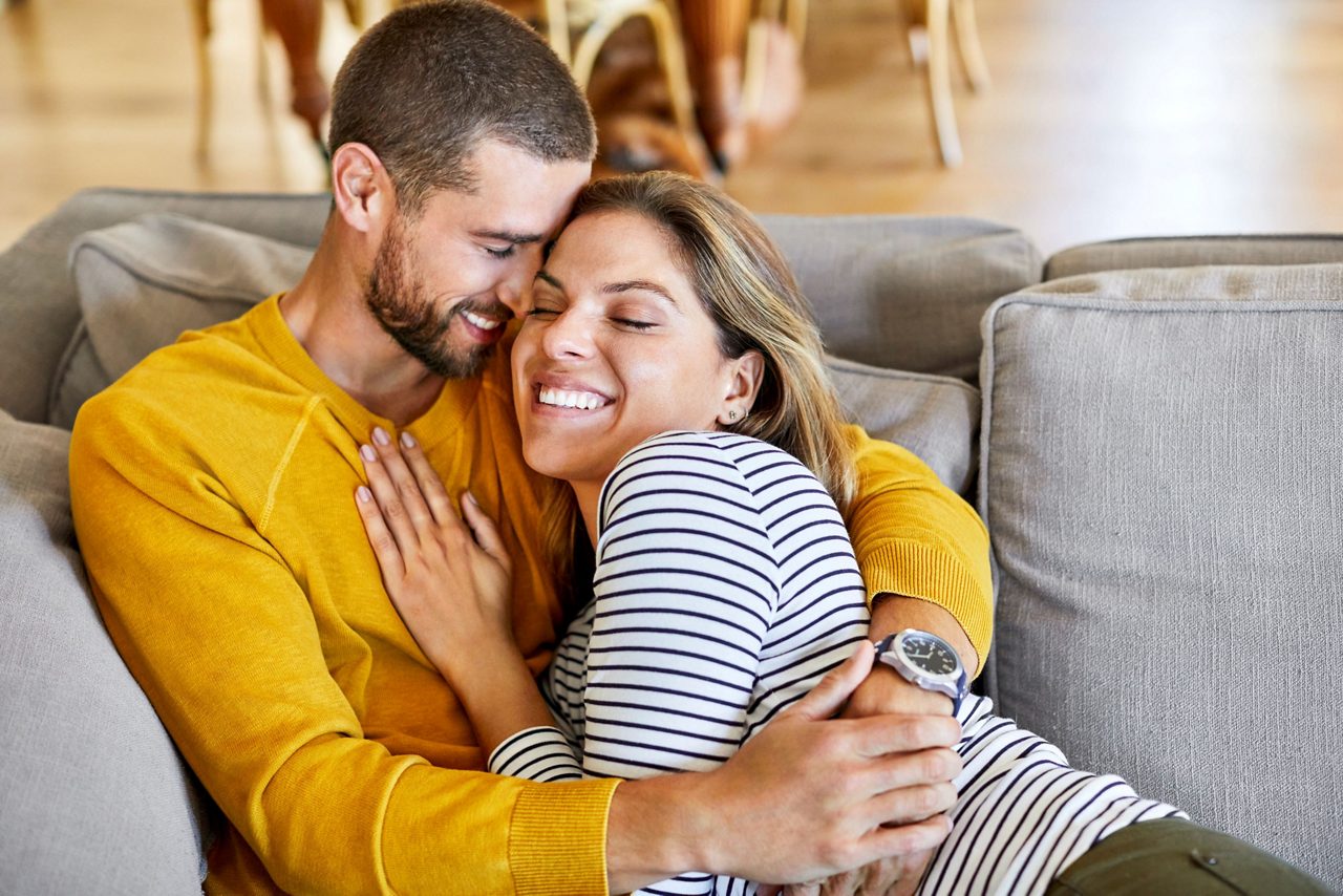 Frau und Mann liegen im Bett und lachen