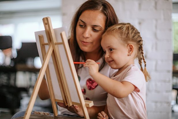 Kind malt mit Mama auf der Leinwand