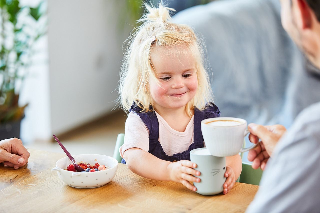 Kleinkind stößt mit Kindermilch an