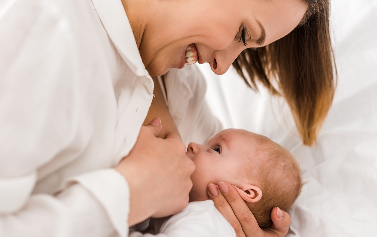 Mutter stillt Baby weißer Hintergrund