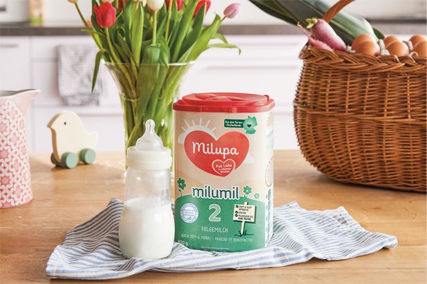 Milumil FO2 neben Fläschchen auf dem Tisch
