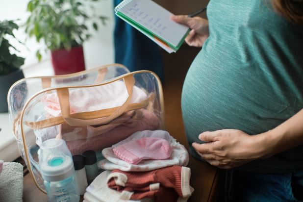 Schwangere Frau packt Kliniktasche