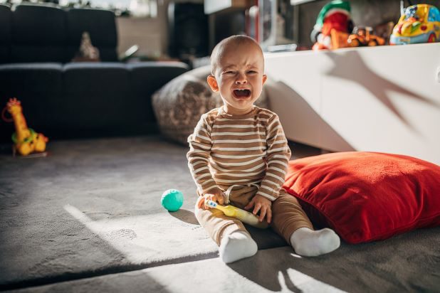 Baby weint auf Arm von Mutter