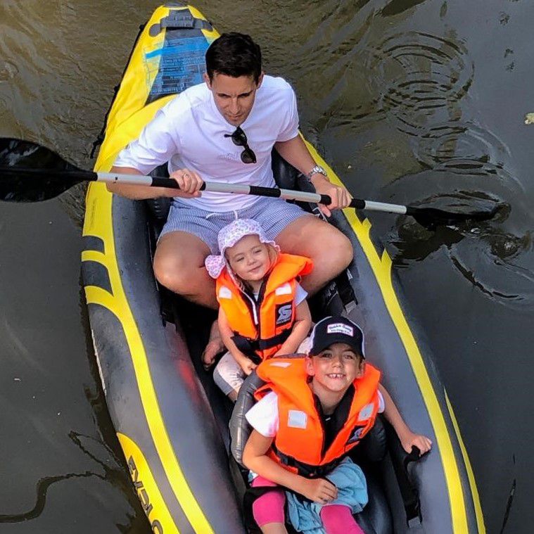 Vater fährt mit zwei Kleinkindern Kanu von oben