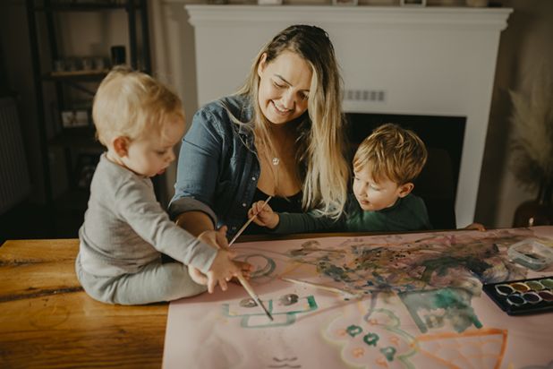 Kleinkinder und Mutter malen mit Wasserfarben
